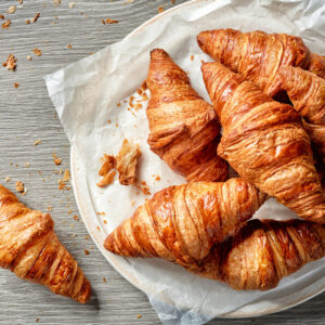 freshly baked croissants on grey wooden table, top view